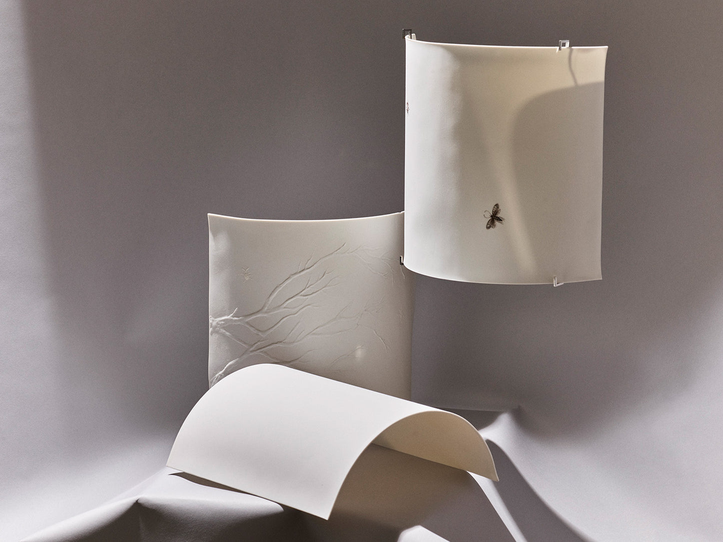 Komposition aus drei Luna-Wandleuchten: „Luna Relief“, „Luna Motive“ und „Luna Pure“ nebeneinander arrangiert.
Composition of three Luna wall lamps: “Luna Relief”, “Luna Motive”, and “Luna Pure” arranged together.